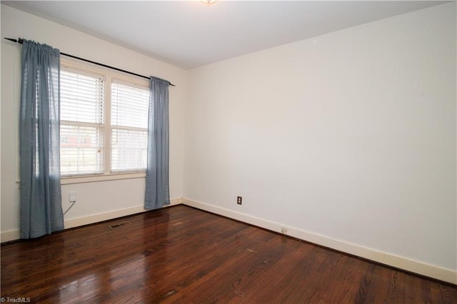 empty room with baseboards and wood finished floors