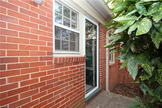 view of exterior entry featuring brick siding