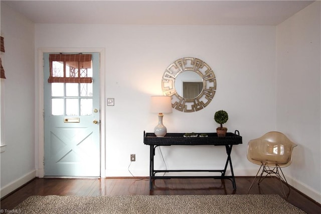 doorway with baseboards and wood finished floors