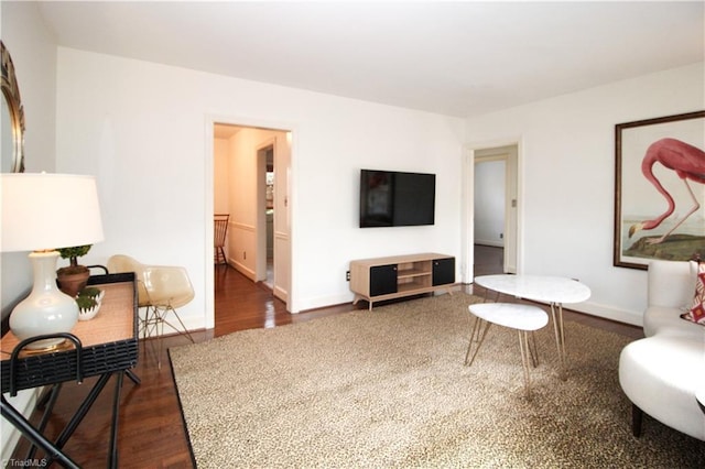 living area featuring baseboards and wood finished floors