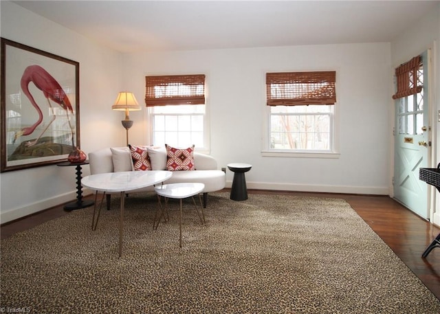 sitting room featuring dark wood-style flooring, plenty of natural light, and baseboards