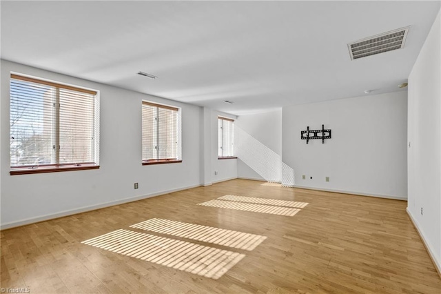 spare room with a healthy amount of sunlight and light hardwood / wood-style floors