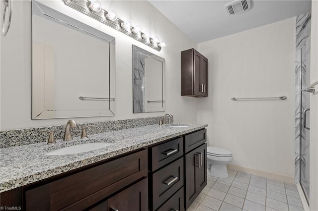 bathroom featuring tile patterned flooring, vanity, walk in shower, and toilet