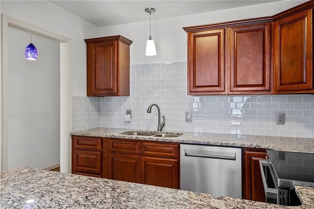 kitchen featuring appliances with stainless steel finishes, sink, decorative backsplash, and decorative light fixtures