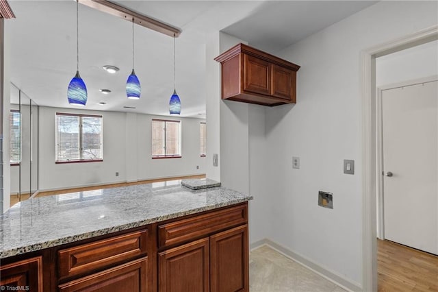 kitchen featuring pendant lighting and light stone counters