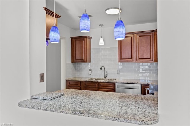 kitchen featuring pendant lighting, dishwasher, sink, and backsplash