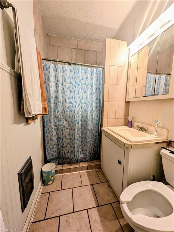 bathroom featuring vanity, toilet, and a textured ceiling