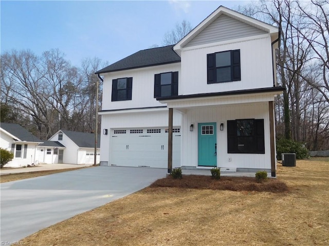 view of front of house with concrete driveway, an attached garage, and central AC