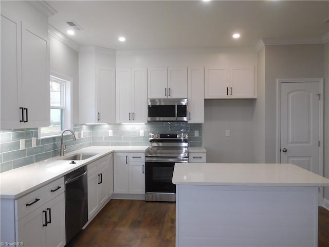 4391 Old Town Dr, Winston-Salem, NC 27106 - kitchen featuring dark wood finished floors, decorative backsplash, appliances with stainless steel finishes, white cabinetry, and a sink