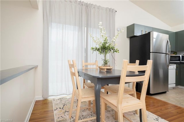 dining space featuring light hardwood / wood-style flooring and vaulted ceiling