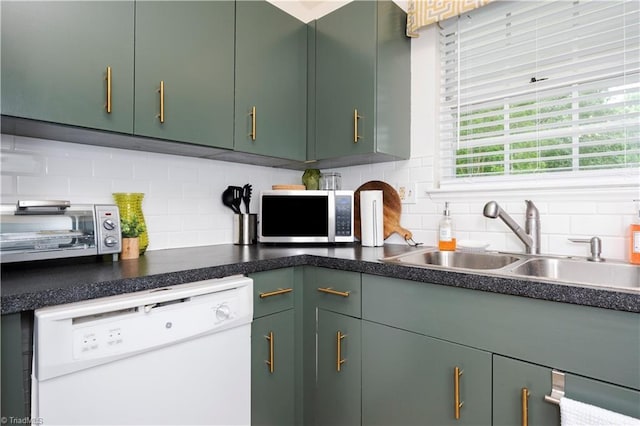 kitchen featuring green cabinets, dishwasher, sink, and decorative backsplash