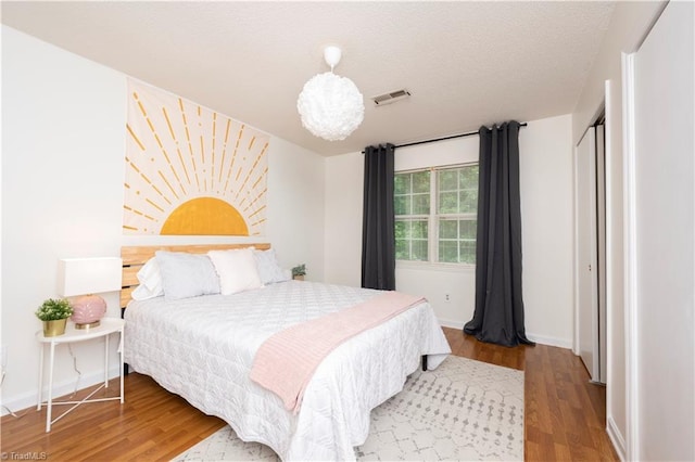 bedroom with wood-type flooring and a textured ceiling