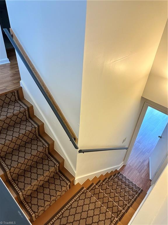 staircase with hardwood / wood-style floors