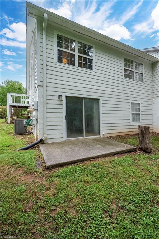 rear view of property with central AC, a lawn, and a patio area