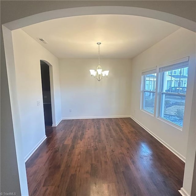 unfurnished dining area with dark hardwood / wood-style flooring and a notable chandelier