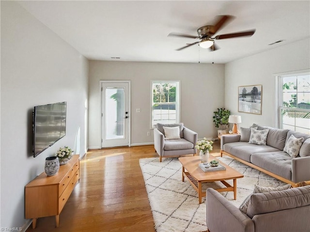 living room with light hardwood / wood-style floors and ceiling fan