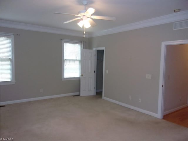 empty room with light colored carpet, ceiling fan, and crown molding