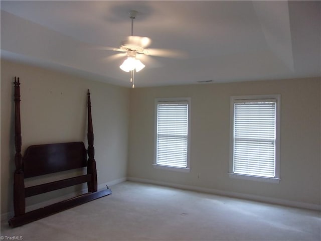 carpeted empty room featuring a wealth of natural light and ceiling fan