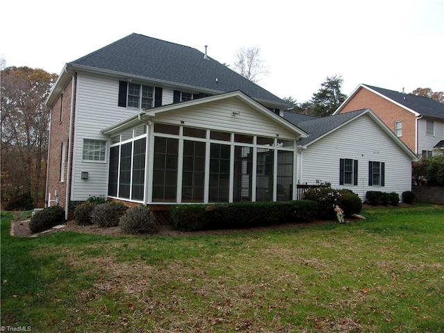 back of house with a sunroom and a lawn