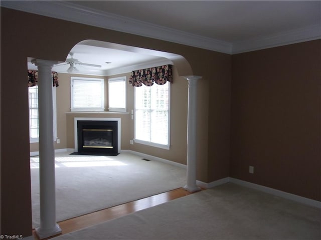 unfurnished living room with ceiling fan, carpet floors, and crown molding