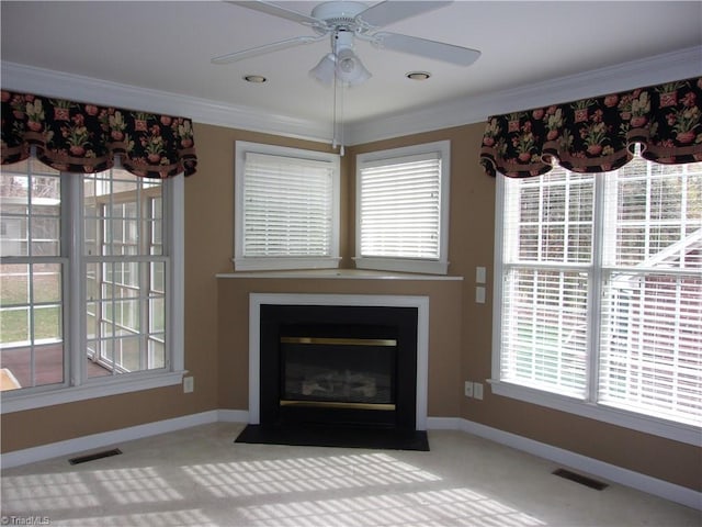 unfurnished living room featuring ornamental molding and a wealth of natural light