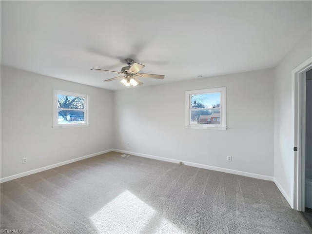 unfurnished room featuring a ceiling fan, carpet flooring, and baseboards