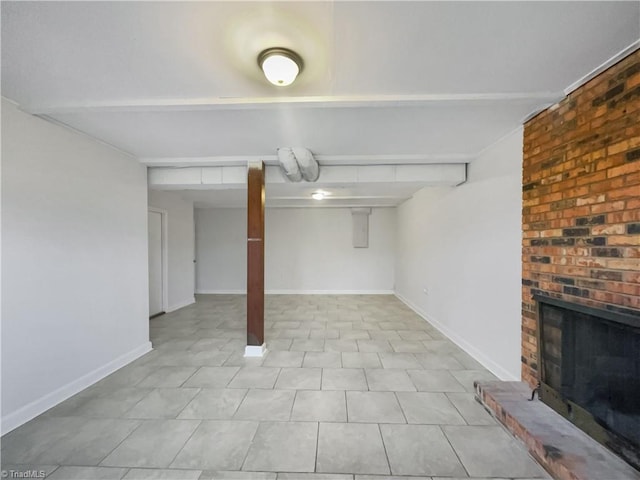 finished below grade area featuring a brick fireplace and baseboards