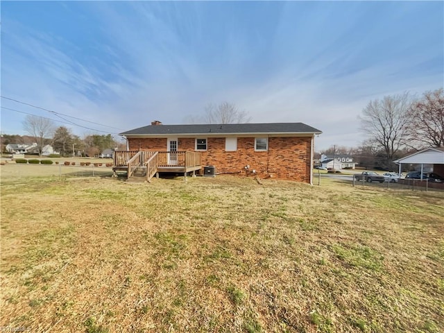 back of house featuring central AC unit, a yard, fence, a wooden deck, and brick siding