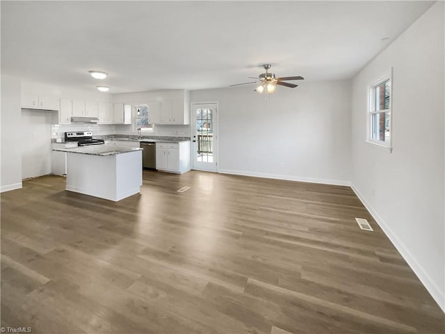 kitchen with white cabinets, dark wood-style floors, a center island, stainless steel appliances, and under cabinet range hood