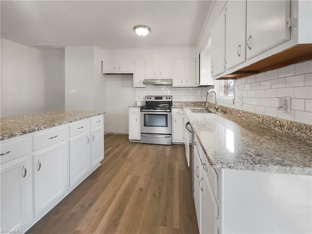 kitchen featuring under cabinet range hood, a sink, white cabinets, backsplash, and stainless steel electric range oven