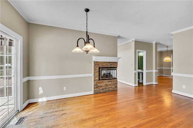 unfurnished living room featuring light wood-style flooring, crown molding, a multi sided fireplace, and baseboards