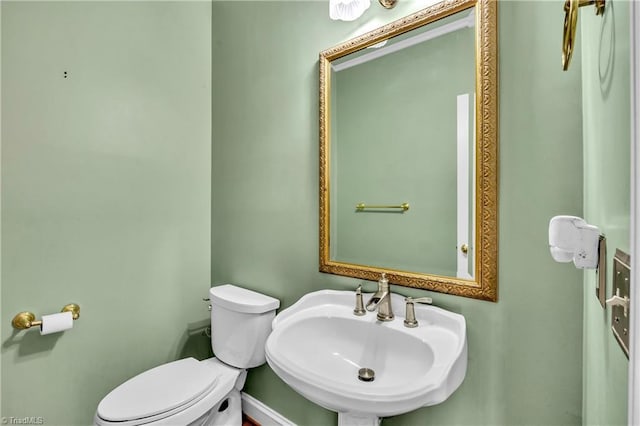 half bathroom featuring a sink and toilet