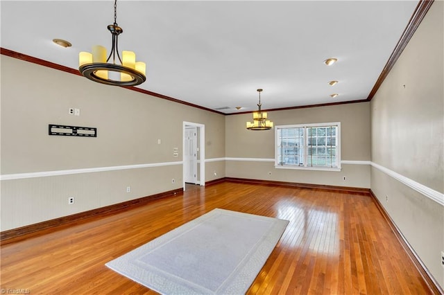 unfurnished dining area with a chandelier, wood-type flooring, baseboards, and ornamental molding
