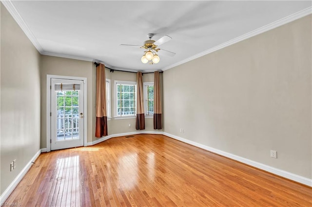 unfurnished room with light wood-style floors, ceiling fan, baseboards, and ornamental molding