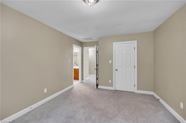 spare room with light carpet and baseboards