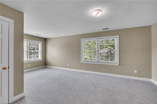 carpeted spare room featuring baseboards
