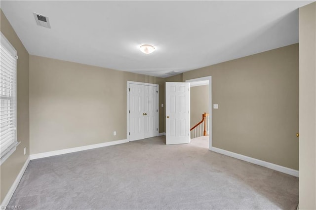 empty room featuring carpet and baseboards