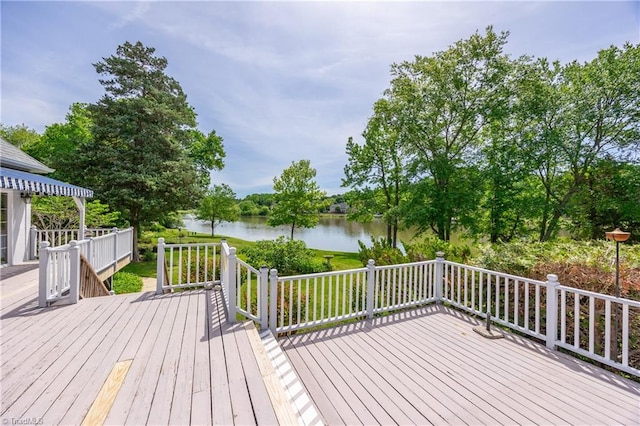 deck with a water view and view of wooded area