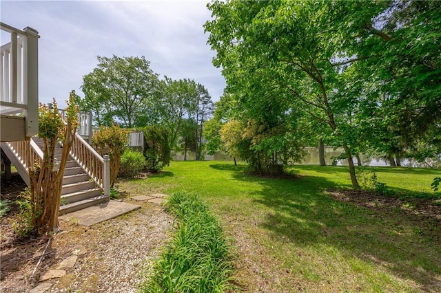 view of grassy yard featuring stairway
