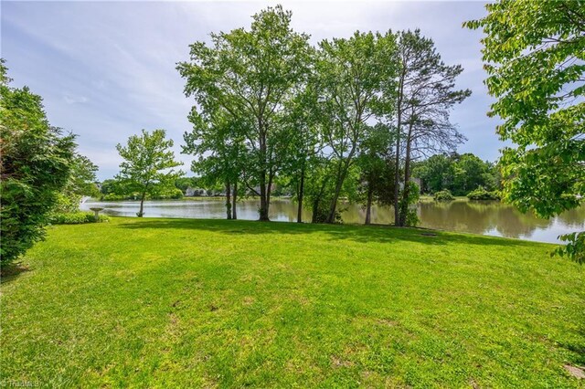 view of green lawn featuring a water view