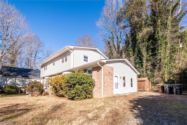 view of side of property with a yard and a storage unit