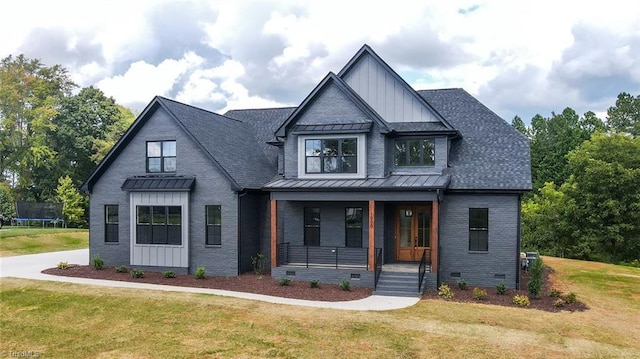 modern inspired farmhouse featuring a trampoline, brick siding, covered porch, board and batten siding, and crawl space