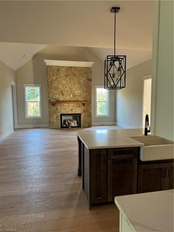 kitchen with dark brown cabinetry, decorative light fixtures, sink, and plenty of natural light