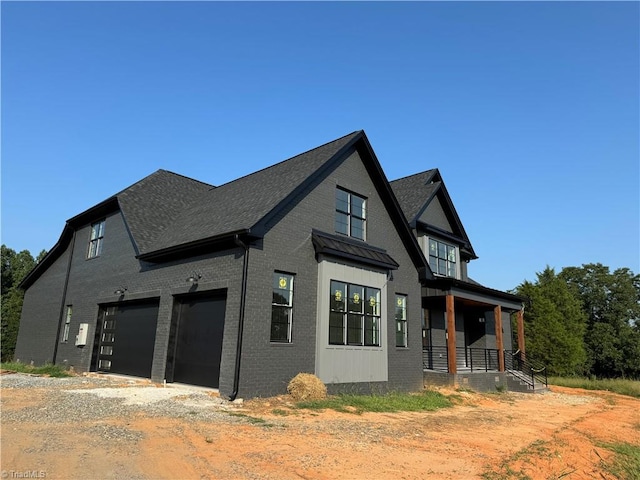 view of home's exterior featuring a garage and covered porch