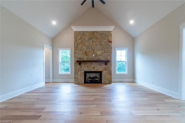 unfurnished living room with light hardwood / wood-style floors, a fireplace, ceiling fan, and a wealth of natural light