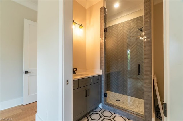 bathroom featuring walk in shower, vanity, and hardwood / wood-style flooring