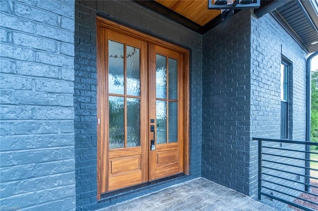 property entrance featuring french doors and brick siding