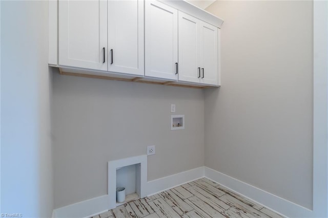 laundry area with hookup for a washing machine, hookup for an electric dryer, and cabinets