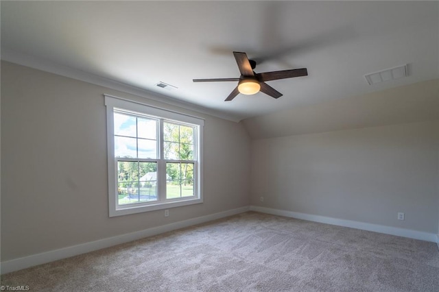 carpeted empty room with ceiling fan, crown molding, and vaulted ceiling