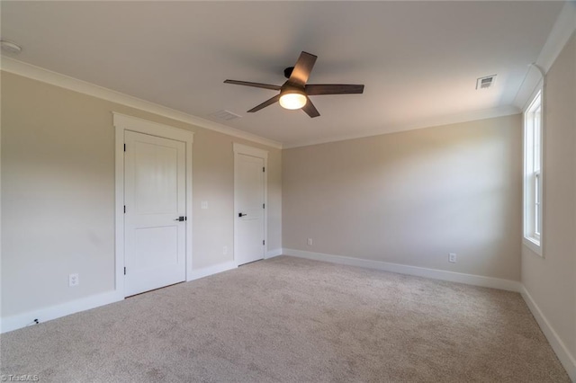 unfurnished bedroom with ornamental molding, ceiling fan, and light carpet